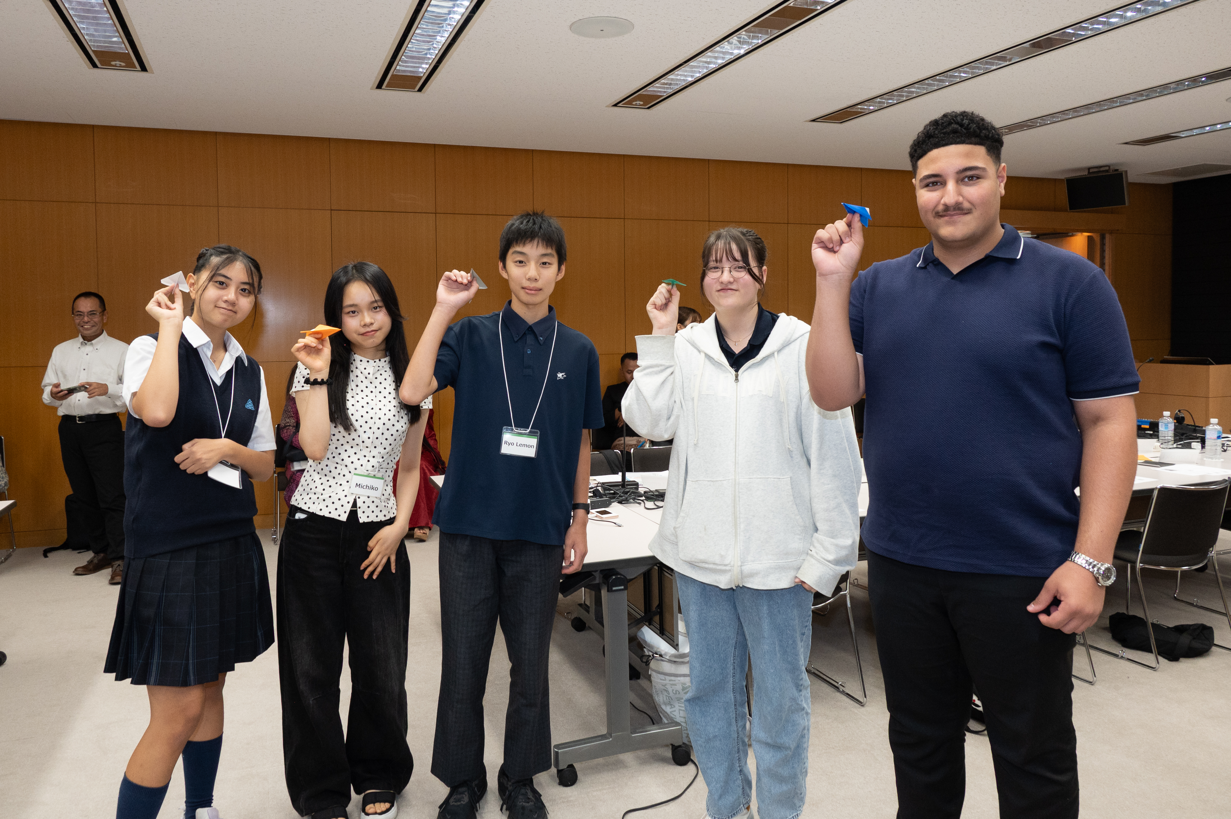 5人で紙飛行機を片手に並んでいる様子