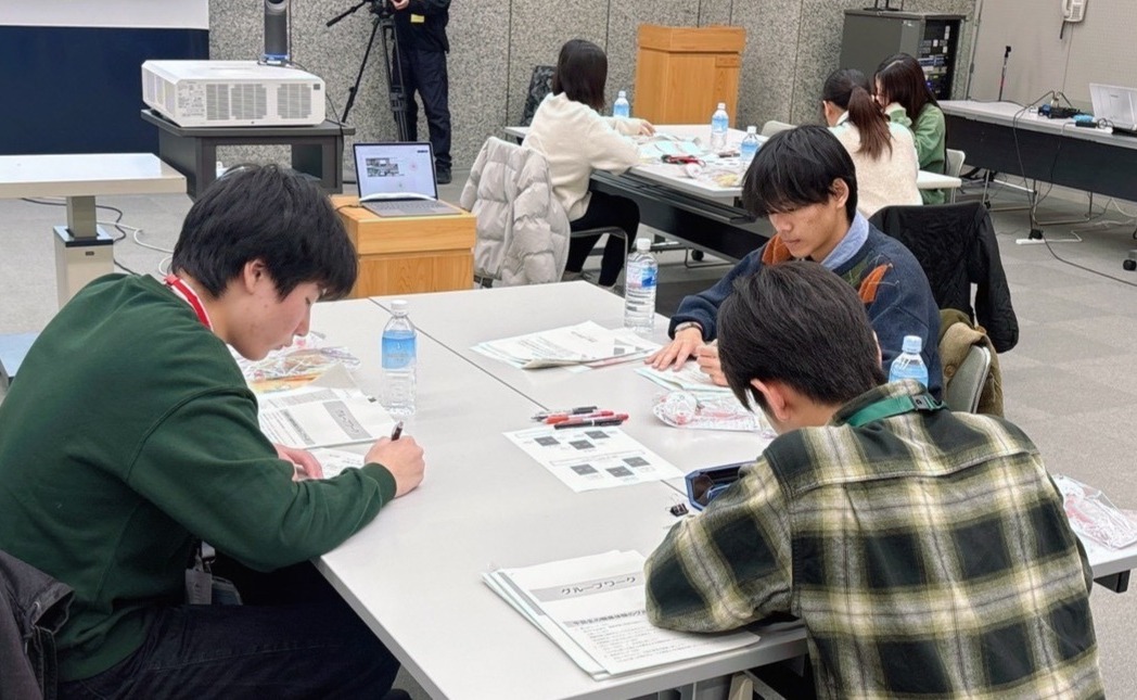 3人の中高生が机で打ち合わせしている様子