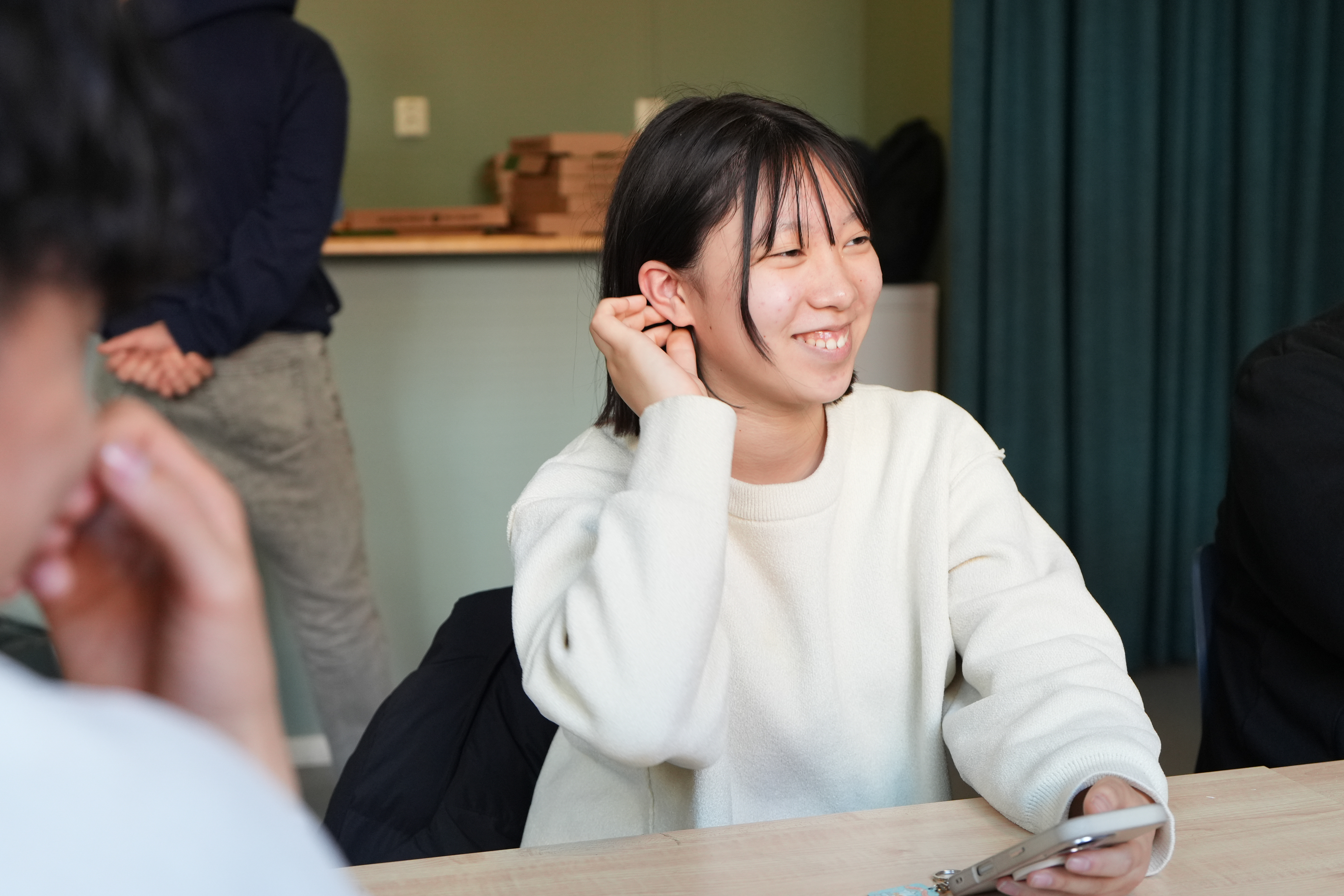 みさきさんが手を右耳にかけている様子