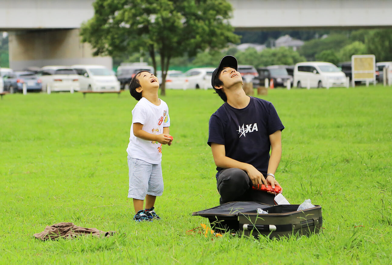 空を見上げる坪井さんとお子さん